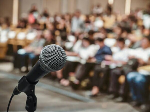 Microphone over the Abstract blurred photo of conference hall or seminar room with attendee background